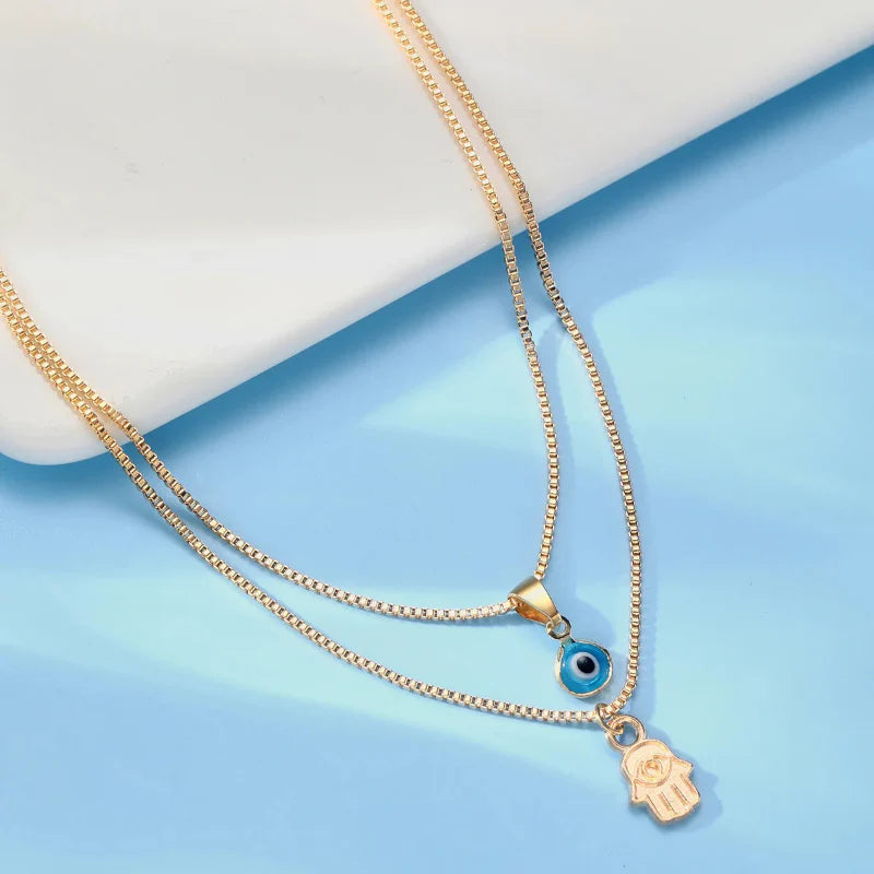 Collar Doble con Colgante Ojo Azul Turco y Mano de Fátima oro