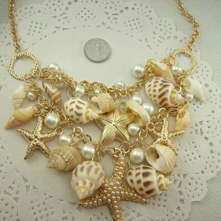 Collar con colgantes de conchas, estrellas de mar, caracoles y perlas