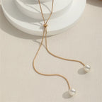 Collar largo con colgante y perlas doradas
