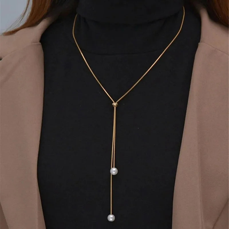 Collar largo con colgante y perlas doradas
